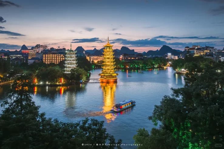 The Sun and Moon pagodas reflected in Shan Lake, Guilin, after dark