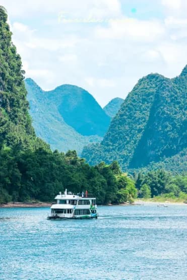 A Li River cruise boat passing between two karst peaks