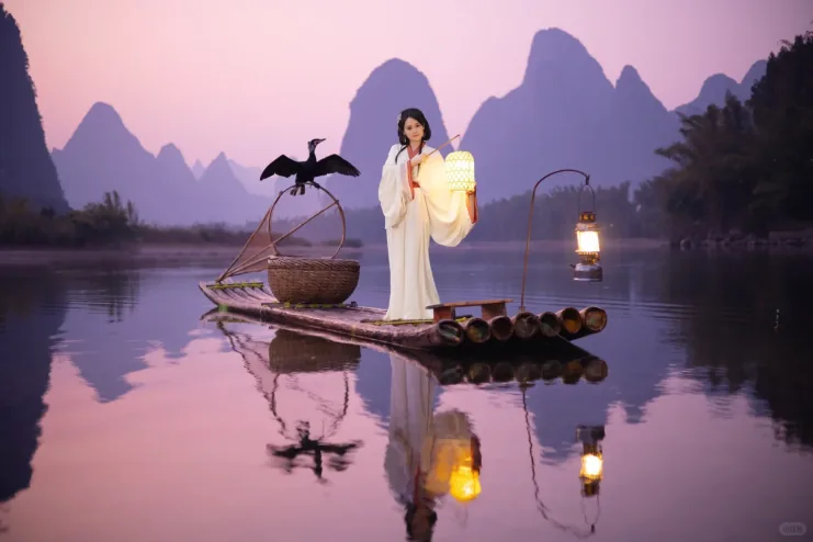 A cormorant on a bamboo raft on the Li River at dusk