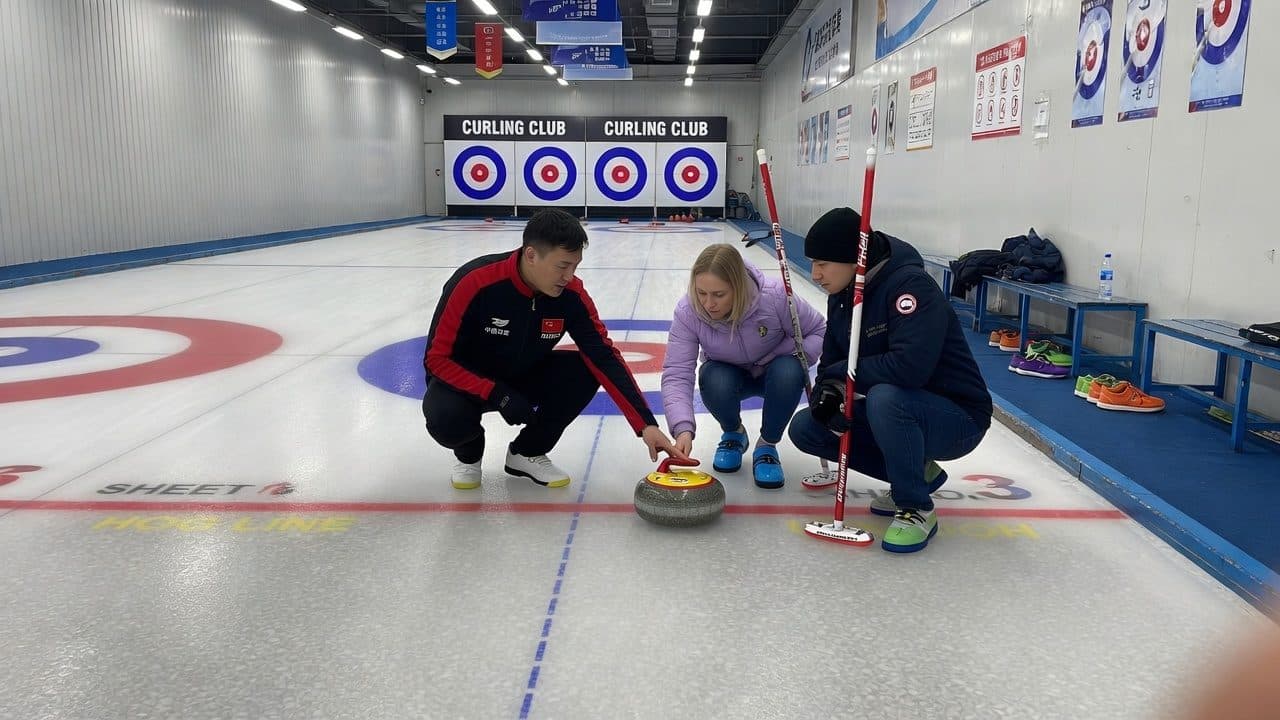 A coach teaching curling on an indoor sheet in Harbin