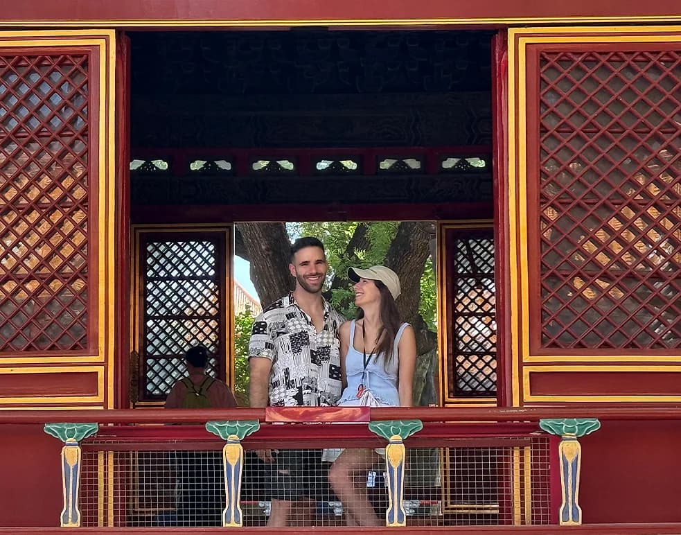 Two visitors framed in a painted palace window