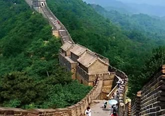 The wall following a steep green ridgeline