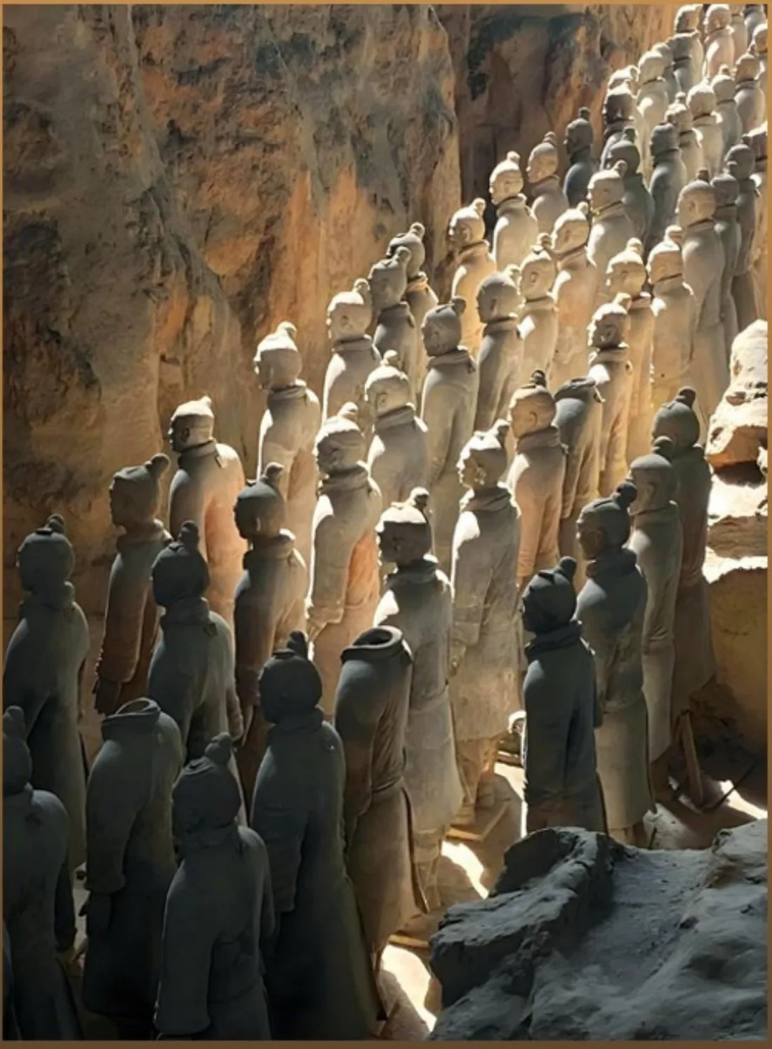 Ranks of terracotta warriors standing in an excavation pit