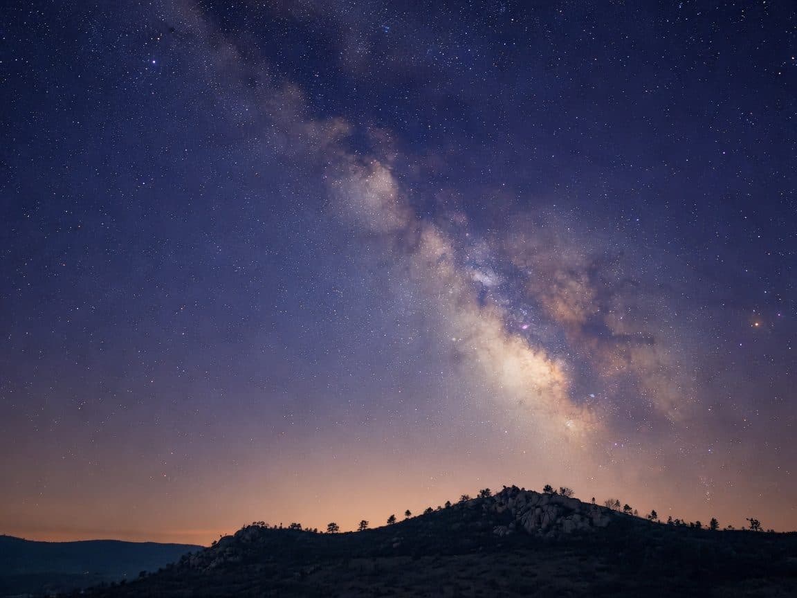 The Milky Way across a dark rural sky above a faint ridgeline