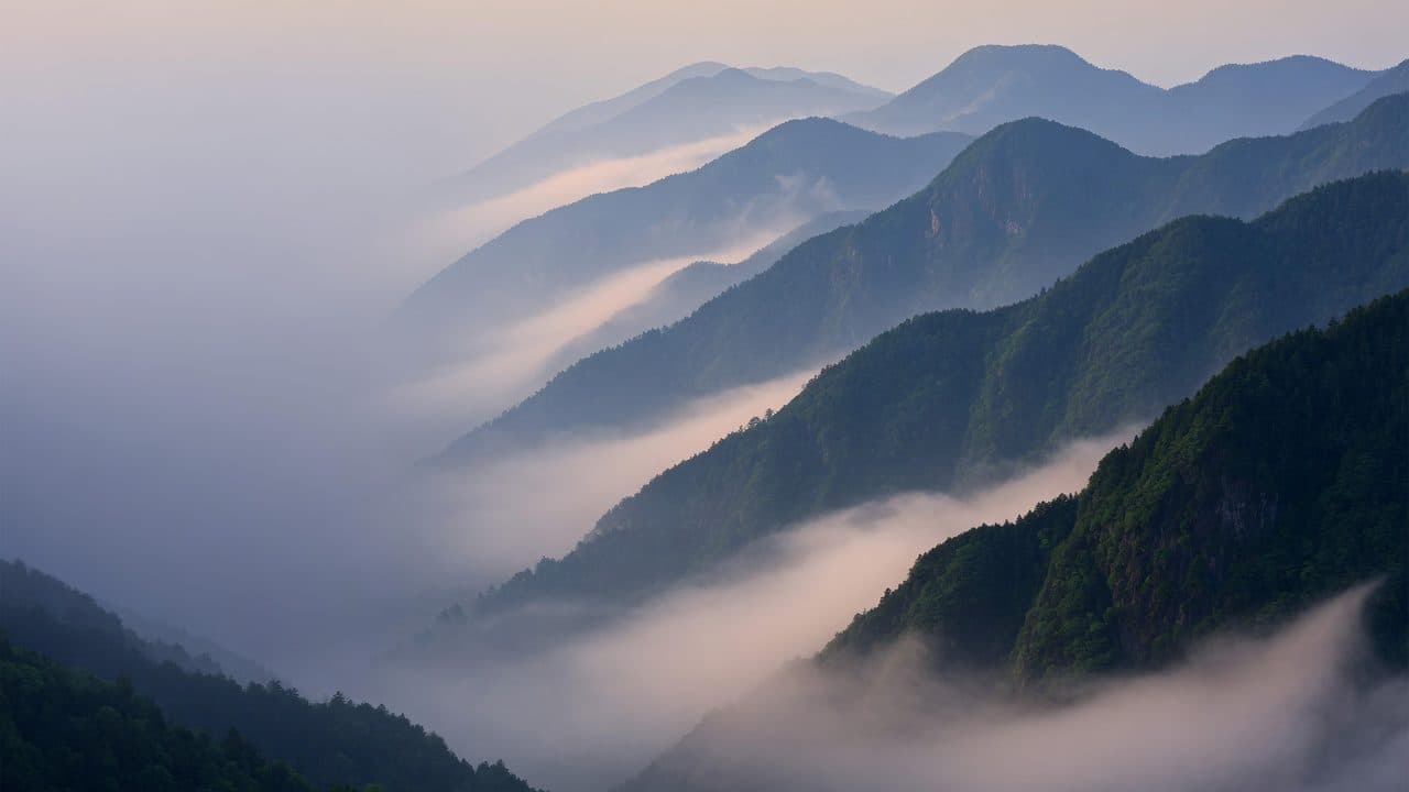 Layered mountain ridges receding into morning mist