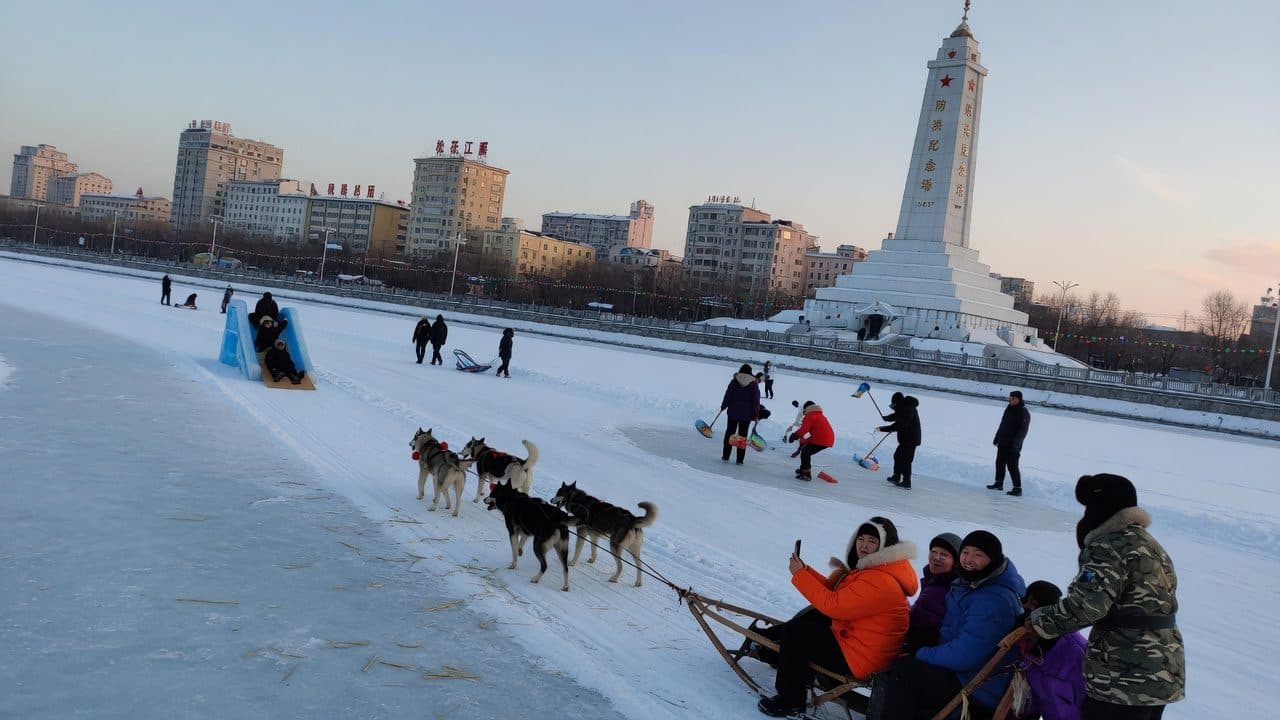 A dog sled team running on the frozen Songhua River at Harbin